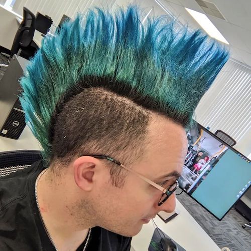 A side profile photo of Az showing a tall teal and blue mohawk, like an ocean.